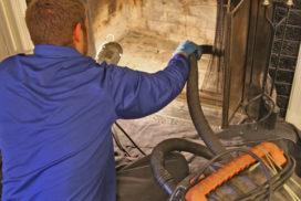 professional doing a deep clean and vacuum of a fireplace
